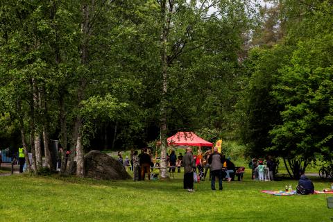Puistoa, taka-alalla ihmisiä.