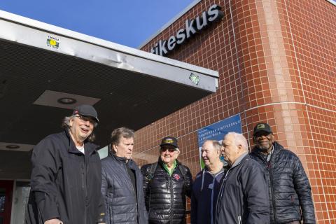 Ali Leppälahti, Seppo Asp, Erkki Räsänen, Kimmo Leinonen, Harri Kanto ja Ronald Fraser ovat kokoontuneena Tampereen uimakeskuksen edessä aurinkoisena kevätpäivänä.
