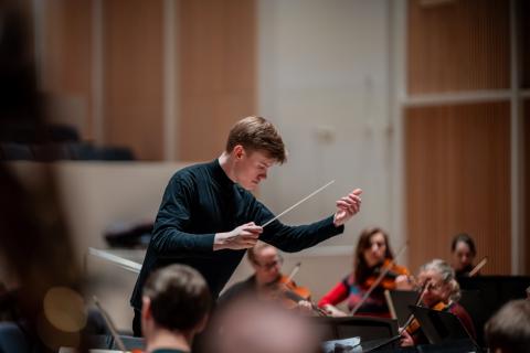 Kapellimestari Kristian Sallinen johtaa Tampere Filharmonia -orkesteria tahtipuikko kädessään.