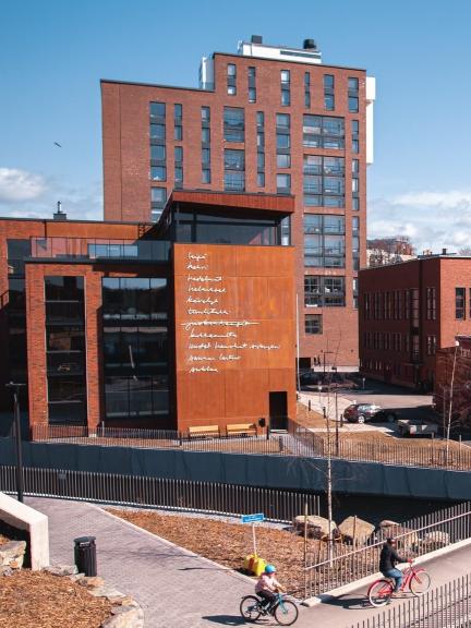 Ranta.Tampellan kerrostaloja, etualalla kaksi pyöräilevää ihmistä.